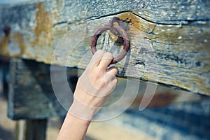 Female hand grabbing rusty chain