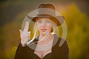 Female hand in gun gesture. Close up face of young stylish woman. Beautiful fashionable girl outdoor portrait.