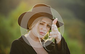 Female hand in gun gesture. Portrait of a young woman, close up face of beautiful woman outdoor. Cheerful female model.
