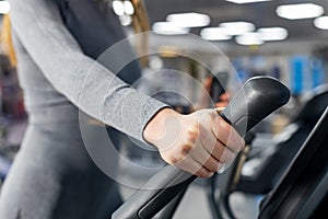 Female hand on the handle of the simulator. workout in the gym