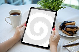 female hand hold computer tablet with isolated screen in cafe