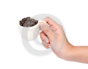 female hand hold cup of coffee beans isolated on white background