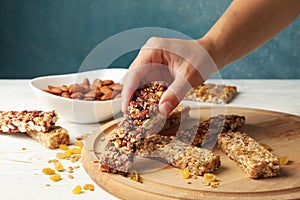 Female hand hold granola bar on background with granola bars