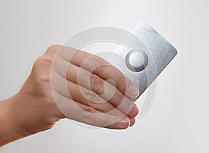 Female hand hold one medical pill in blister pack