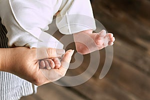 Female hand holding baby foot.