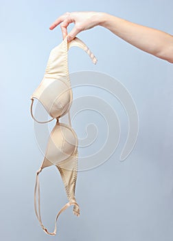 Female hand holding beige bra