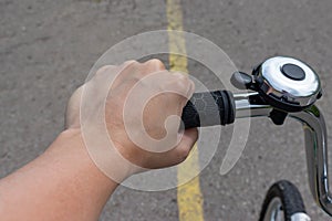 Female hand holding a bicycle handlebar and riding a bike on a road with yellow marking, bicycle travelling and journey