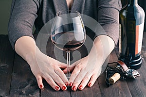 Female hand holding big glass of red wine