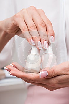 Female hand holding bottles of nail polish