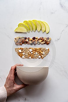 Female hand holding bowl with healthy breakfast concept on white background