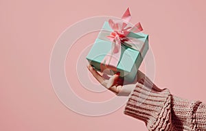 female hand holding boxed gift with ribbon