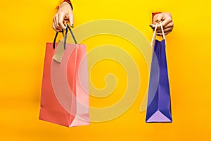 Female hand holding bright shopping bags