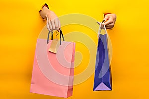 Female hand holding bright shopping bags