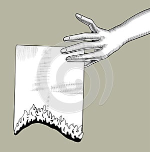 Female hand holding a burning paper sheet