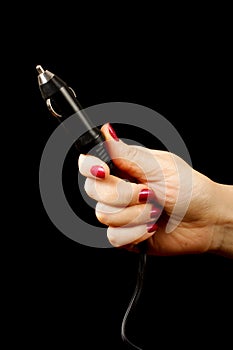 Female hand holding car cigarette lighter plug isolated