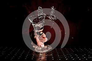 Female hand holding a cocktail glass filled with a fresh drink