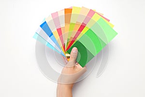 Female hand holding color palettes on white background