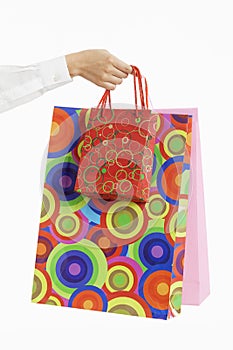 Female hand holding colorful shopping bags