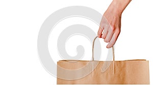 Female hand holding creft paper bag isolated on white.