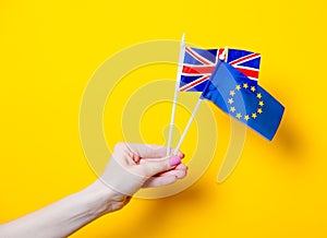 Female hand holding EU and Great Britain flags