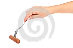 Female hand holding fork with sausage. Isolated on white background