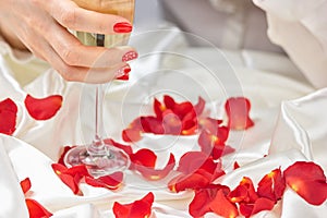 Female hand holding glass of champagne.