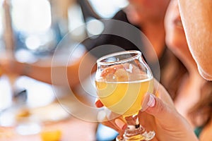 Female Hand Holding Glass of Micro Brew Beer At Bar