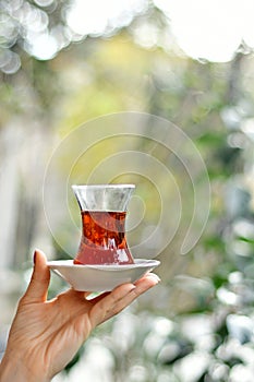 Female hand holding glass of turkish tea