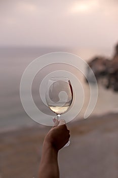 Female hand holding a glass of white wine