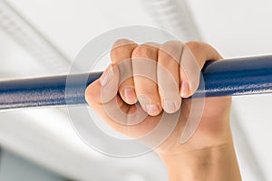 Female hand holding the handrail in public transport