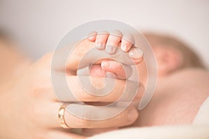 Female hand holding her newborn baby`s hand. Mom with her child. Maternity, family, birth concept. Copy space for your