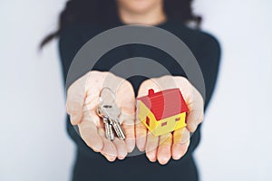 Female hand holding house key, real estate agent