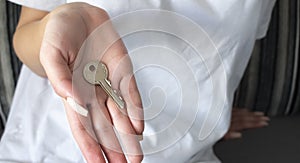 Female hand holding house key,real estate agent