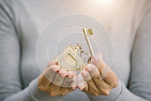 Female hand holding house key, real estate agent concept
