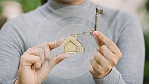 Female hand holding house key, real estate agent concept