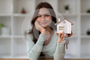 Female hand holding house key, real estate agent woman working house loan at her office