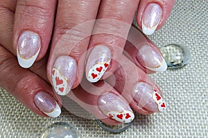 the female hand is holding a manicured manicure with hearts