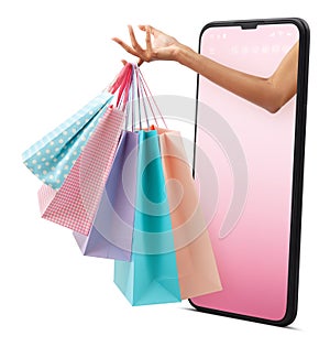 Female hand holding many shopping bag pink and light blue color. Coming out from mobile phone with pink screen. Isolated on white