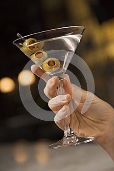 Female hand holding martini.