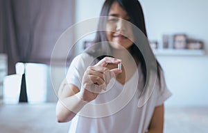 Female hand holding a medicine,Woman hands with pills on spilling pills but do not take a medicine ,emotional face expression photo