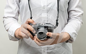 Female hand holding modern camera mirrorless camera.