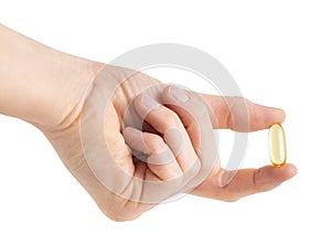 Female hand holding omega capsule isolated on white background with clipping path.