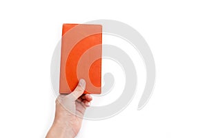 Female hand holding an orange notebook. photo
