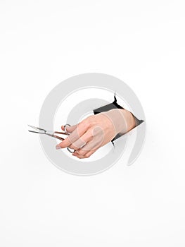 Female hand holding pair of scissors