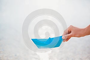 Female hand holding paper boat