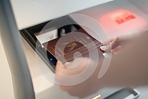 Female hand holding personal passport scaning at the self service checkin counter for get boarding pass at the airport terminal