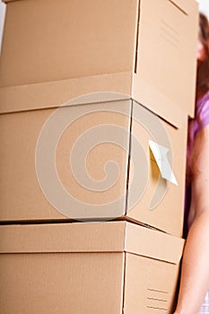 Female hand holding pile of brown cardboard boxes