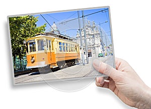 A female hand holding an postcard about the historical trasportation of Porto - on background the `Igreja do Carmo e Carmelitas` c