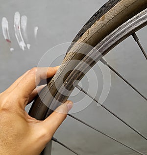 female hand holding a punctured bicycle tire
