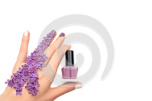 Female hand holding purple nail polish bottle. Spring concept